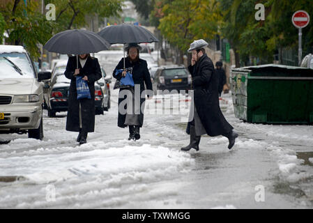 Ultra-Orthodox Jews walk in snow and rain during a winter storm in Jerusalem, Israel, January 8, 2015.  A heavy winter storm is hitting the Middle East, while only 5 cm. or 1 inch of snow fell in Jerusalem. UPI/Debbie Hill Stock Photo