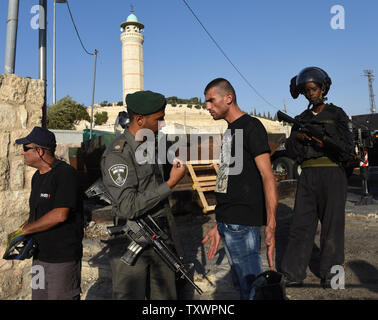 An Israeli border police argues with a Palestinian near newly installed concrete roadblocks at the entrance to the Palestinian neighborhood of Ras al-Amud  in East Jerusalem, October 14, 2015. Israel is setting up roadblocks at the entrances to several Arab neighborhoods around Jerusalem and deploying hundreds of troops in major cities following a series of shooting and stabbing attacks by Palestinians on Israelis.  Photo by Debbie Hill/ UPI Stock Photo