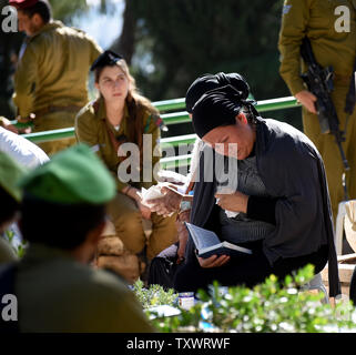 An Israeli prays at the grave of a family member on Israel's  Memorial Day for fallen soldiers and terror victims in the Mount Herzl Military Cemetery in Jerusalem, Israel May 11, 2016.  Israel is marking Memorial Day to commemorate 23,477 fallen soldiers and 2,517 civilians killed in terror  attacks hours before the country's mourning turns to festivities when Israel's 68th Independence Day begins Wednesday night. Photo by Debbie Hill/UPI Stock Photo