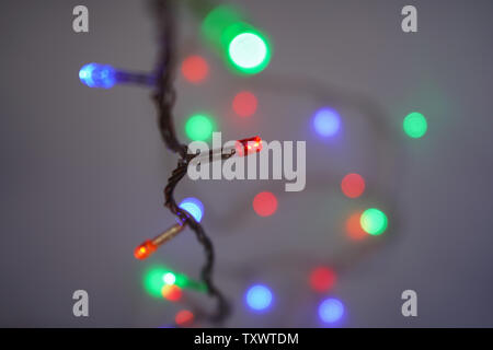 Christmas multicolor lights. Electric lights. Decorative garland. Light bulbs on the wire Stock Photo