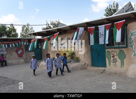 Palestinian bedouin children walk outside the Khan al Ahmar school in the West Bank, August 17, 2016.  The adobe school was built in 2009 with international funds and serves 160 students from first to ninth grades.The Palestinian Authority has started a campaign calling on the international community to stop the Israel Civil Administration from razing the school, which was issued with demolition orders in 2009. Nearby Israeli settlers have filed new petitions to the High Court to demolish the school and Bedouin encampments where some 100 families live in the desert. Photo by Debbie Hill/ UPI Stock Photo