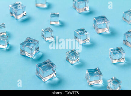 Ice cubes scattered on a light blue background. Stock Photo
