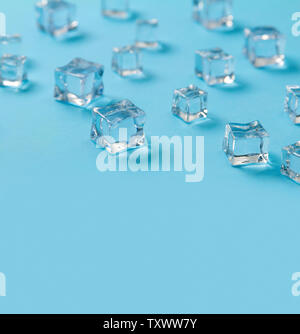 Ice cubes scattered on a light blue background. Stock Photo