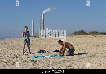 Israel's electric power plant is seen in the distance in Ashkelon, as Israelis enjoy the beach  near Kibbutz Zikim, on the Israeli-Gaza border, June 22, 2017.  This week Israeli's National Electric Company cut it's limited electricity supply to the Gaza Strip after the Palestinian Authority refused to pay Hamas' electricity bills. On Wednesday, Egypt supplied 1.1 million liters of diesel fuel to Gaza, which is expected to last four days, running at 50 percent it's capacity. Photo by Debbie Hill/UPI Stock Photo
