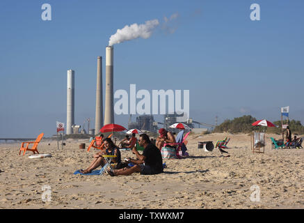 Israel's electric power plant is seen in the distance in Ashkelon, as Israelis enjoy the beach on the Mediterranean Sea near Kibbutz Zikim, on the Israeli-Gaza border, June 22, 2017.  This week Israeli's National Electric Company cut it's limited electricity supply to the Gaza Strip after the Palestinian Authority refused to pay Hamas' electricity bills. On Wednesday, Egypt supplied 1.1 million liters of diesel fuel to Gaza, which is expected to last four days, running at 50 percent it's capacity. Photo by Debbie Hill/UPI Stock Photo