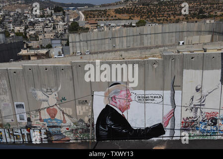 An overview of Israel's controversial separation wall with graffiti of U.S. President Donald Trump in the biblical city of Bethlehem, West Bank, August 9, 2017. The graffiti depicts Trump wearing a Jewish skullcap and thinking 'I'm going to build you a brother' in reference to the wall he has promised to build on the Mexican border.   -   Photo by Debbie Hill/UPI Stock Photo