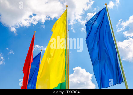 Colorful flags in the wind against the blue sky background Stock Photo