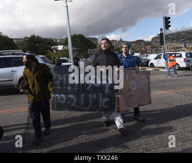 Israeli settlers carry signs reading 'Jewish Blood is Not Spilled In Vain' at the site where a Palestinian gunman killed two Israeli soldiers and seriously wounded two more, in a drive by shooting at a bus stop outside the Givat Assaf Outpost, near Ramallah, West Bank, December 13, 2018. The gunman disembarked his vehicle, opened fire and fled the scene. The Israeli army put a closure on Ramallah and is searching for the shooter. Photo by Debbie Hill  /UPI Stock Photo