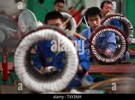 Chinese factory workers assemble electric bikes on the assembly line at ...