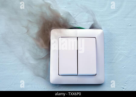 Electrical fires are a major cause of fires in the home. Smoke and burn marks on electric light switch. Stock Photo