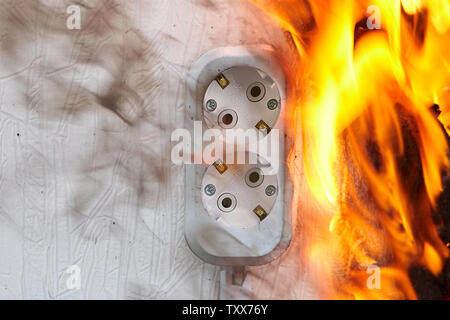 Improperly wired outlet causes House fire. Burnt socket due to overload or loose connection. Stock Photo