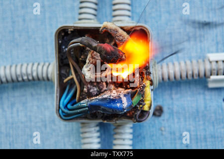 Damaged electrical junction box became cause of electrical short circuit and caused the electric wiring to ignition of fire. Stock Photo