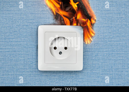 Faulty outlets, fire from electrical appliances malpractice. Burnt damaged plug socket causes home fire. Stock Photo