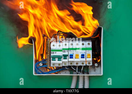 Damaged circuit breaker became the cause of electrical short circuit and caused the switchboard to ignite of fire. Bad electrical wiring systems cause Stock Photo