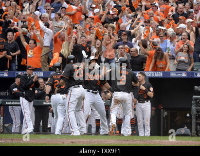 Baltimore Orioles Jimmy Paredes C high fives teammate J.J. Hardy 2 after Hardy Nelson Cruz and Steve Pearce scored on an RBI double hit by Delmon Young during the eighth inning of game