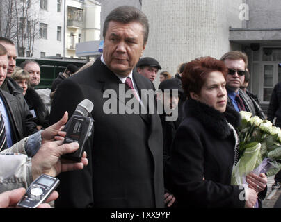 Main Ukrainian opposition leader Viktor Yanukovych (L) answers a journalist's question, as he and his wife Luydmila (R) leave after voting in the parliament elections in Kiev, March 26, 2006. Former Prime Minister Yanukovich was a main rival of Ukrainian leader Victor Yushchenko in the presidential elections in 2004. (UPI Photo/Sergey Starostenko) Stock Photo