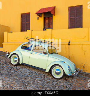 Square photograph of a renovated vintage car or old timer in a colourful street with orange facade of Bo Kaap district, Cape Town, South Africa. Stock Photo