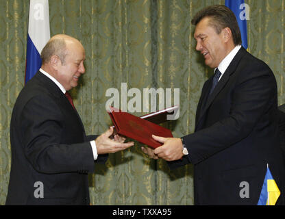 Russian Prime Minister Mikhail Fradkov (L) and Ukrainian counterpart Viktor Yanukovych exchange documents after the signing of a bilateral cooperation agreement at the government house in Kiev on October 24, 2006. Ukrainian government has received confirmation from Russia to secure at least 55 billion cubic meters of gas at no higher than $130 per 1,000 cubic meters next year, Yanukovich said on Tuesday. ((UPI Photo/Sergey Starostenko) Stock Photo