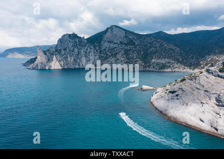 boat floats in the blue Bay at the rocks Stock Photo