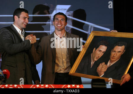 Former WBC heavyweight boxing champion Vitali Klitschko (L) and his younger brother Vladimir pose with their portrait after a news conference in Kiev on March 16, 2007. The Ukrainian boxers announced their plans for the future. (UPI Photo/Sergey Starostenko)