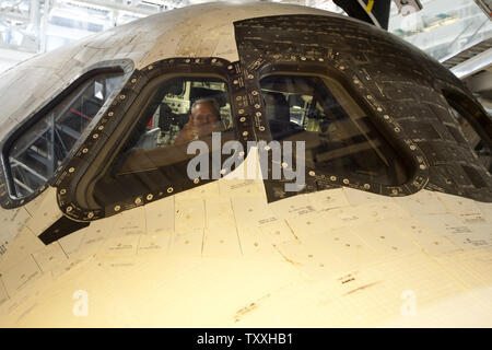 A NASA technician gives a 'thumbs up' as he sits in the flight deck of NASA's space shuttle 'Atlantis' as it is towed into Orbiter Processing Facility 2 following completion of the space shuttle's final mission at the Kennedy Space Center on July 21, 2011. Atlantis will be powered down and 'safed' prior to being put on display at the Kennedy Space Center Visitor Complex. Atlantis completed her 33rd and the shuttle program's 135th and final mission with a  predawn landing. Atlantis flew to the International Space Station on mission STS 135 and provided equipment and supplies for the next year. Stock Photo