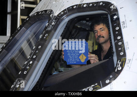 A NASA technician holds a sign that was flown on board the space shuttle 'Atlantis' as it is towed into Orbiter Processing Facility 2 following completion of the space shuttle's final mission at the Kennedy Space Center on July 21, 2011. Atlantis will be powered down and 'safed' prior to being put on display at the Kennedy Space Center Visitor Complex. Atlantis completed her 33rd and the shuttle program's 135th and final mission with a  predawn landing. Atlantis flew to the International Space Station on mission STS 135 and provided equipment and supplies for the next year.          .UPI/Joe M Stock Photo