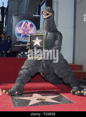 Film character 'Godzilla' holds a replica plaque during a ceremony honoring him with the 2,271st star on the Hollywood Walk of Fame in Hollywood, California November 29, 2004. The movie icon celebrates its 50th anniversary with the star as well as the premiere of the film 'Godzilla Final Wars' later in the day.    (UPI Photo/Jim Ruymen) Stock Photo