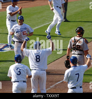 Los Angeles Dodgers's center fielder Milton Bradley (L) pulls on his jersey  and is congratulated by Jeff Kent after his bases-loaded single scored the  winning runs in the Dodgers' 9-8 victory over