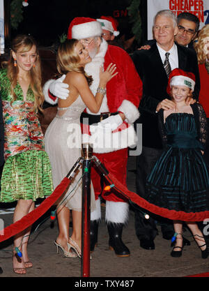 Cast member Carmen Electra (2nd-L) receives a kiss from Santa Claus as fellow cast members Hilary Duff (L), Steve Martin (3rd-R), Eugene Levy (R) and Lilian Mumy (lower right) look on at the premiere of the motion picture family comedy 'Cheaper by the Dozen 2' in Los Angeles December 13, 2005. The movie opens in the United States Dec. 21.  (UPI Photo/Jim Ruymen) Stock Photo