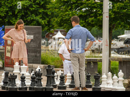 KELOWNA, BRITISH COLUMBIA, CANADA - JUNE 2018: People playing chess on a large set in a public park near the town centre in Kelowna, BC. Stock Photo