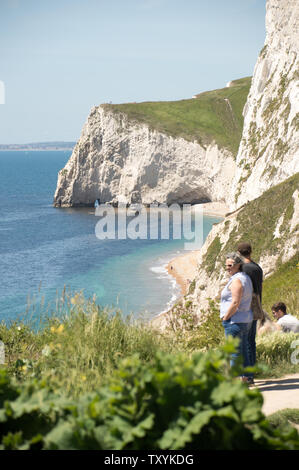 People enjoying the Jurrasic coast view from the cliff top on a sunny afternoon