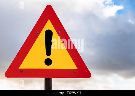 Hazard ahead warning road sign against cloudy sky Stock Photo