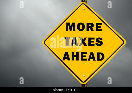 More taxes ahead conceptual warning road sign with stormy sky in background Stock Photo