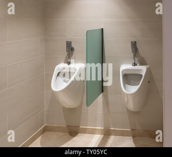 Two automatic flush urinals in mens restroom Stock Photo