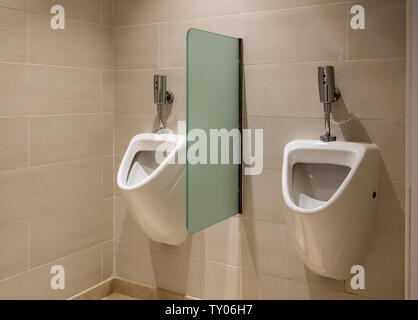 Two automatic flush urinals in mens restroom Stock Photo