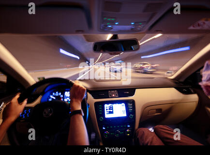 View from the car interior at the windshield and front driving cars inside tunnel - car dashboard defocused light trails