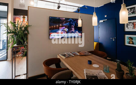Haarlem, Netherlands - Aug 17, 2018: Upscale hotel lobby with digital flat screen tv showing CNN news channel with braking news Music legend Aretha Franklin dies at age 76 - singing at Obama inauguration Stock Photo