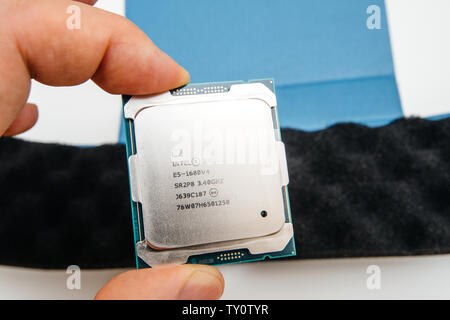 London, United Kingdom - May 15, 2019: Above macro view of new powerful new E5-1680 V4 Intel Xeon professional CPU processor Broadwell FCLGA2011-3 man hand unboxing new high tech device Stock Photo