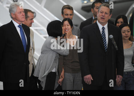 Laura Ling (C) one of two American journalists who were arrested in March  after allegedly crossing into North Korea from China, is kissed by her  mother Mary as Euna Lee (R) looks