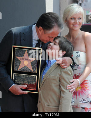 Actor George Hamilton holds a replica plaque after accepting his star on the Hollywood Walk of Fame in Los Angeles on August 12, 2009. Hamilton, who received the 2,388th star during an unveiling ceremony poses with his girlfriend, Dr. Barbara Sturm and his son G.T.     UPI Photo/Jim Ruymen Stock Photo
