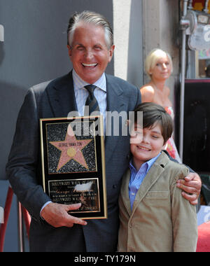 Actor George Hamilton holds a replica plaque after accepting his star on the Hollywood Walk of Fame in Los Angeles on August 12, 2009. Hamilton, who received the 2,388th star during an unveiling ceremony poses with his girlfriend, Dr. Barbara Sturm and his son G.T.     UPI Photo/Jim Ruymen Stock Photo