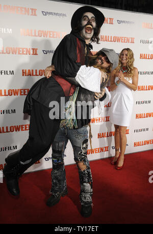 Director Rob Zombie (C) and cast member Sheri Moon Zombie (R) are greeted by a man in costume at the premiere of 'Halloween II' in Los Angeles on August 24, 2009.      UPI/ Phil McCarten Stock Photo