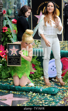 A woman dressed as Tinker Bell,  as the fairy character who sprang from the pages of J.M Barrie's literary classic, 'Peter Pan', is honored with the 2,418th star on the Hollywood Walk of Fame in Los Angeles on Septermber 21, 2010. Walking off are actresses Mae Whitman (L), the voice of Tinker Bell and Raven-Symone, the voice of Iridessa.     UPI/Jim Ruymen Stock Photo
