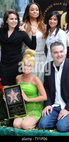 Tinker Bell, the fairy character who sprang from the pages of J.M Barrie's literary classic, 'Peter Pan', kneels beside director Bradley Raymond (R) and Mae Whitman, Raven-Symone and Pamela Adlon (L-R, rear), as Tinker Bell is honored with the 2,418th star on the Hollywood Walk of Fame during an unveiling ceremony in Los Angeles on September 21, 2010.     UPI/Jim Ruymen Stock Photo