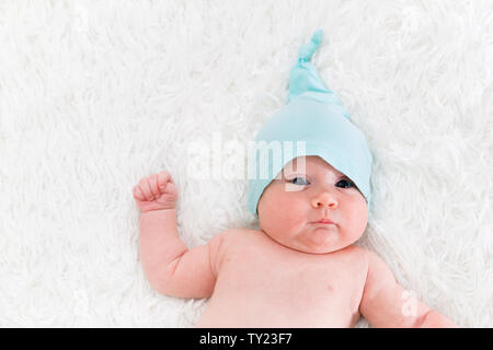 A one month old new born rests happily in her blanket. Stock Photo