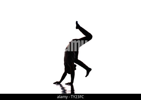 An urban guy is doing handstand in the studio while dancing modern dance Stock Photo