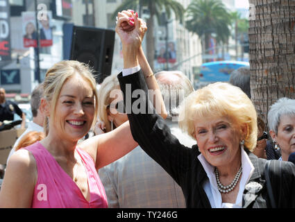 Actress Sharon Stone raises the hand of singer Jane Morgan (L) as Morgan is honored with the 2,439th star on the Hollywood Walk of Fame during an unveiling ceremony in Los Angeles on May, 6, 2011. Morgan has six gold records and was a frequent guest on 'The Ed Sullivan Show'. Stock Photo