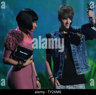 Singer Justin Bieber (R) accepts the best male hip hop artist for Kanye West from co-presenter Nicki Minaj during the 2011 BET Awards at the Shrine Auditorium in Los Angeles on June 26, 2011.  UPI/Jim Ruymen Stock Photo