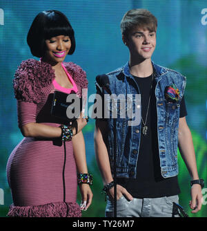 Singer Justin Bieber (R) accepts the best male hip hop artist for Kanye West from co-presenter Nicki Minaj during the 2011 BET Awards at the Shrine Auditorium in Los Angeles on June 26, 2011.  UPI/Jim Ruymen Stock Photo