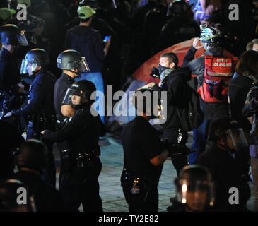 Angola Riot Police Two riot police officers move along a pavement past closed storefronts ...
